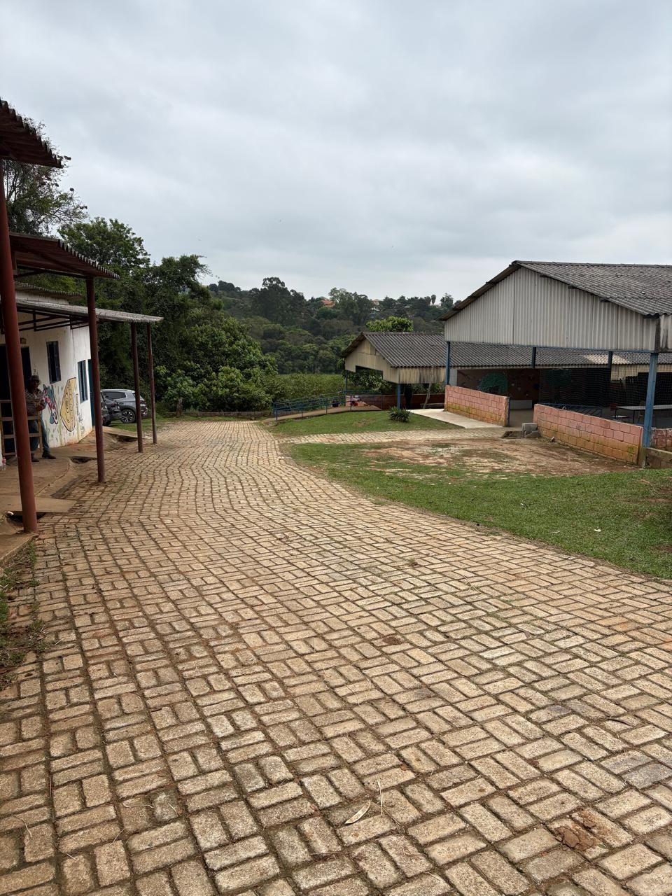 Caminho de bloquetes entre as cocheiras e o gramado.